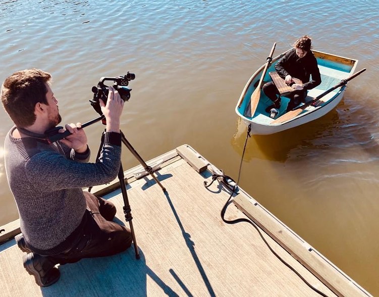 Daniel Portelli holding camera of boat on water